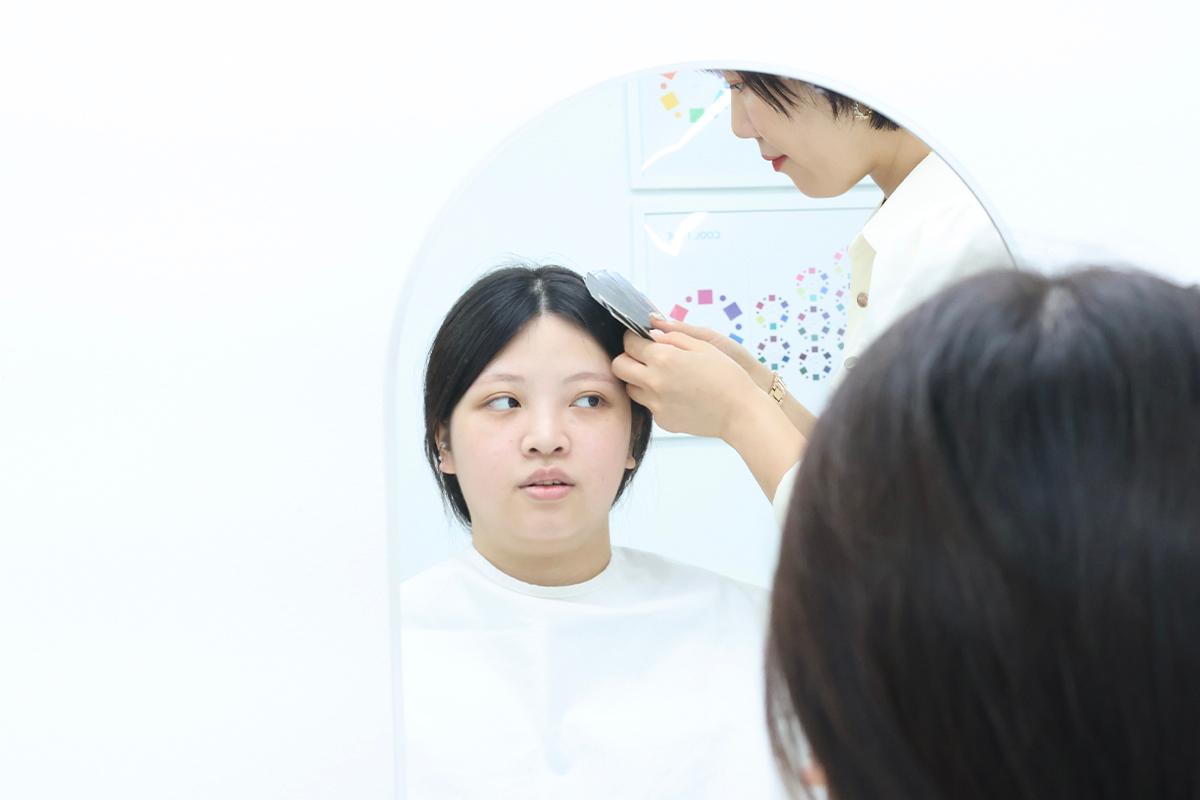 Consultant placing a color fabric underneath the chin to assess suitable colors during consultation.