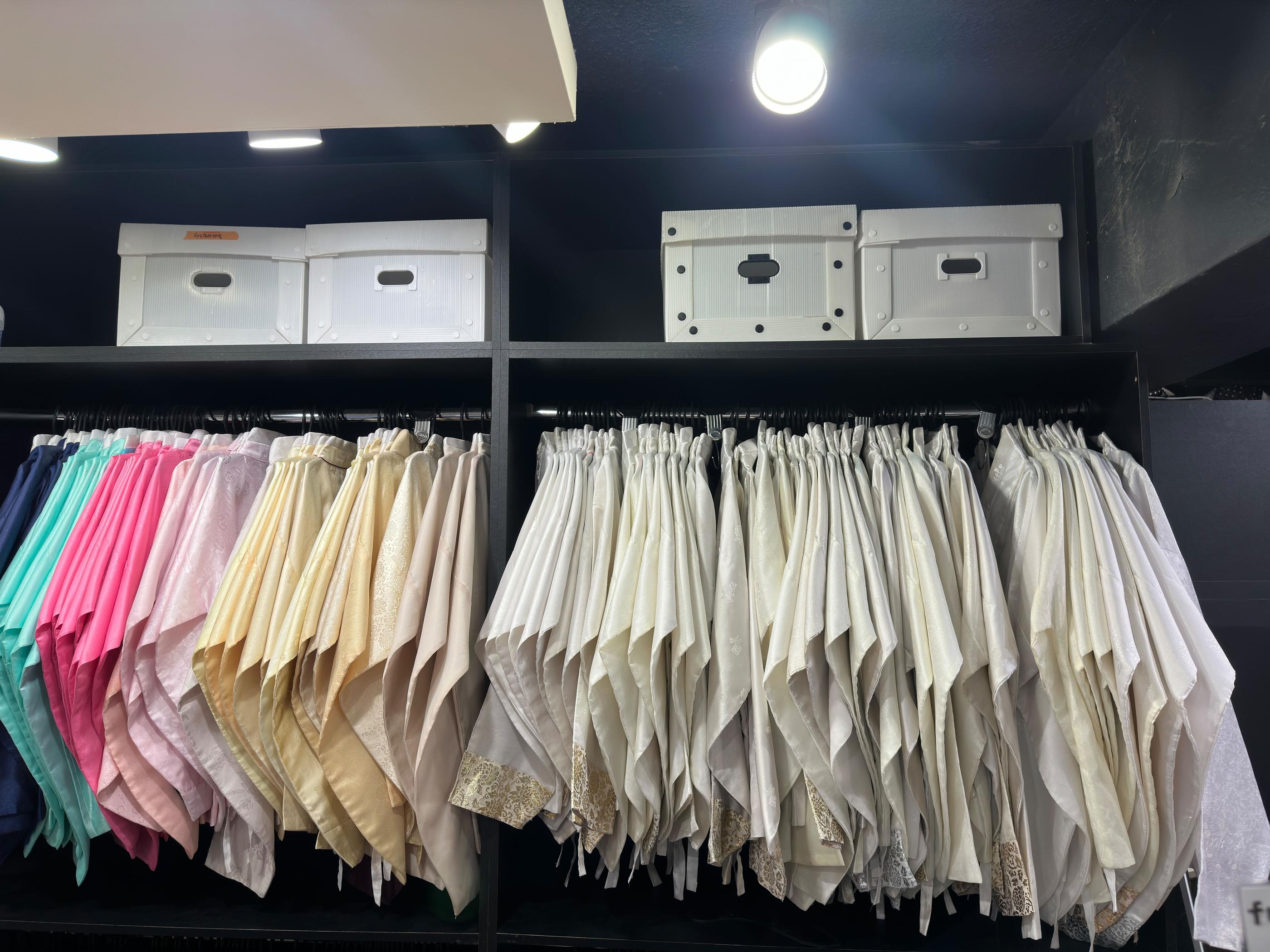 玩天韓服店內展示的韓服裙子，櫥櫃上整齊掛放多種顏色與款式，讓顧客輕鬆選擇和搭配。