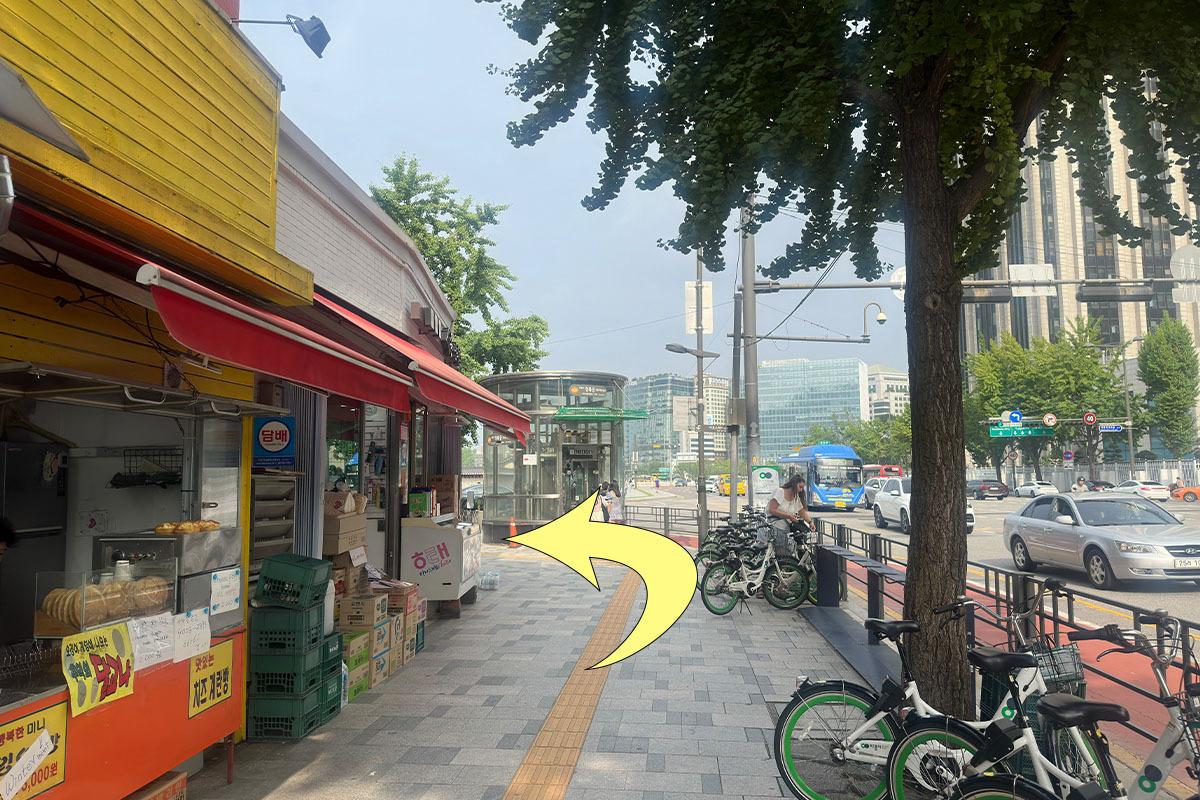 在首爾街道上行走的方向，展示韓服租賃店所在的建築外部環境。