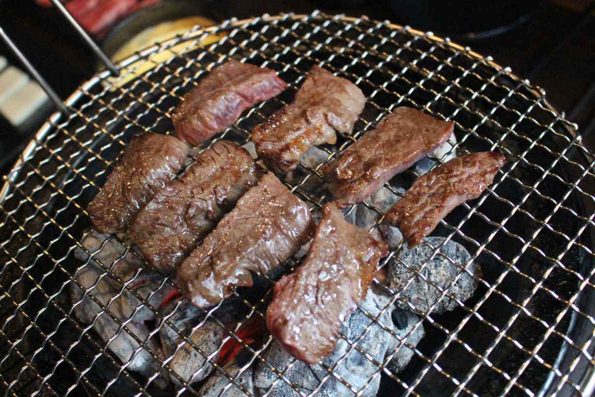 在火气爱爱建大本店的烤炉上，烧烤中的牛肉。