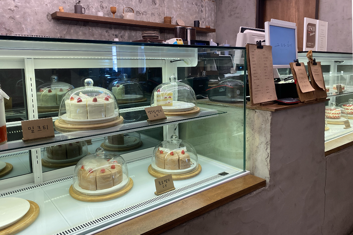 그자체咖啡厅柔和内饰设计，窗边是舒适的沙发和细致的装饰。