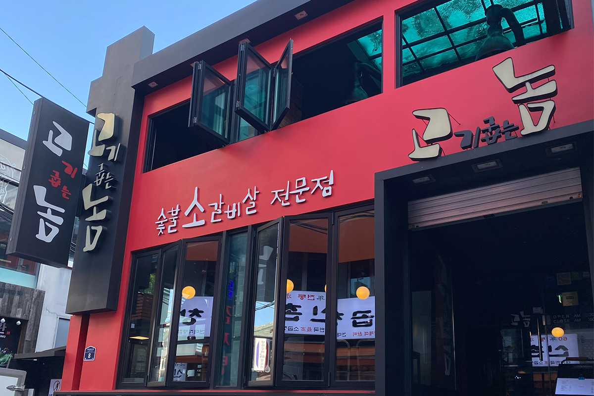 红色建筑的烤肉店“고기굽는놈”的正面，位于韩国建大地区。