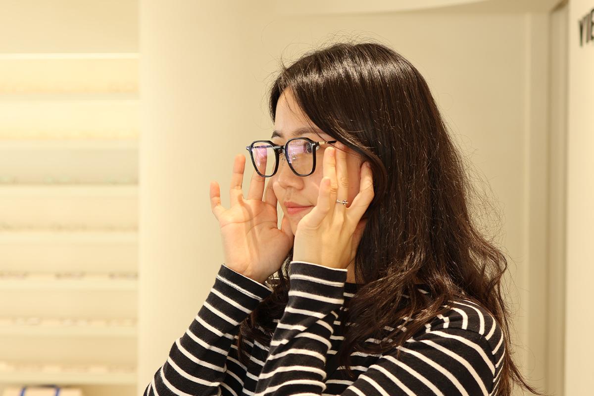 Customer trying eyeglasses in VIEWMAP's bright and modern interior.