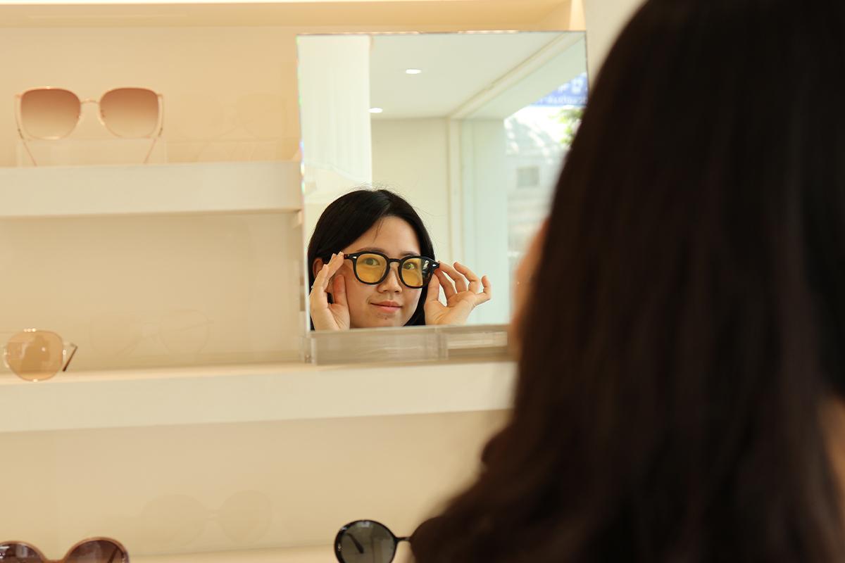VIEWMAP shopper trying on glasses in front of a mirror in the store.
