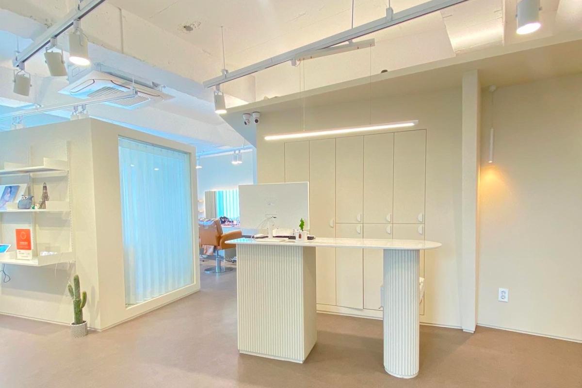 韓國首爾弘大美容院『and Allis』大廳,室內設計簡潔優雅,燈光明亮,室內陳設有化妝鏡和化妝椅,提供專業的美容服務。