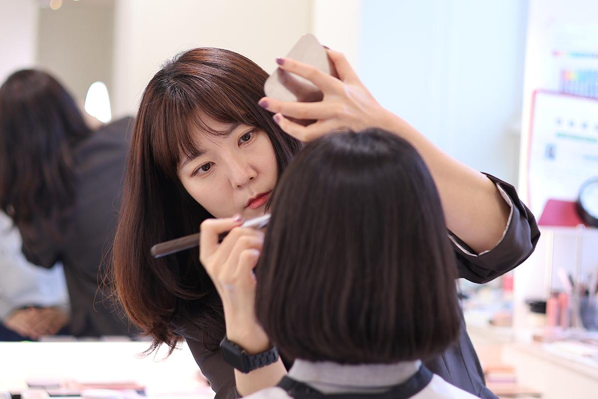 化妝過程展示,化妝師正在進行美容作業,展現細緻的化妝技巧。