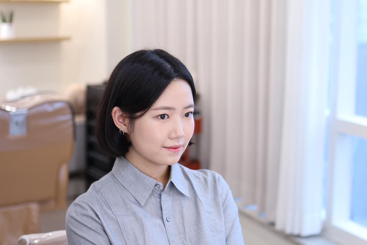 化妝師正在進行面部亮色遮瑕,化妝過程展示了細緻化妝技巧。