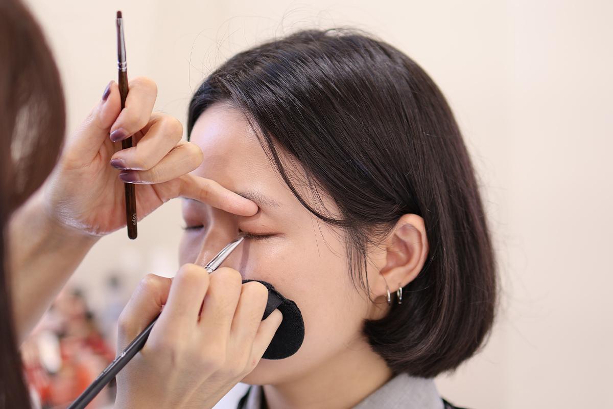 化妝過程中眉毛造型的細節展示,化妝師的專業技術顯示其精緻性。