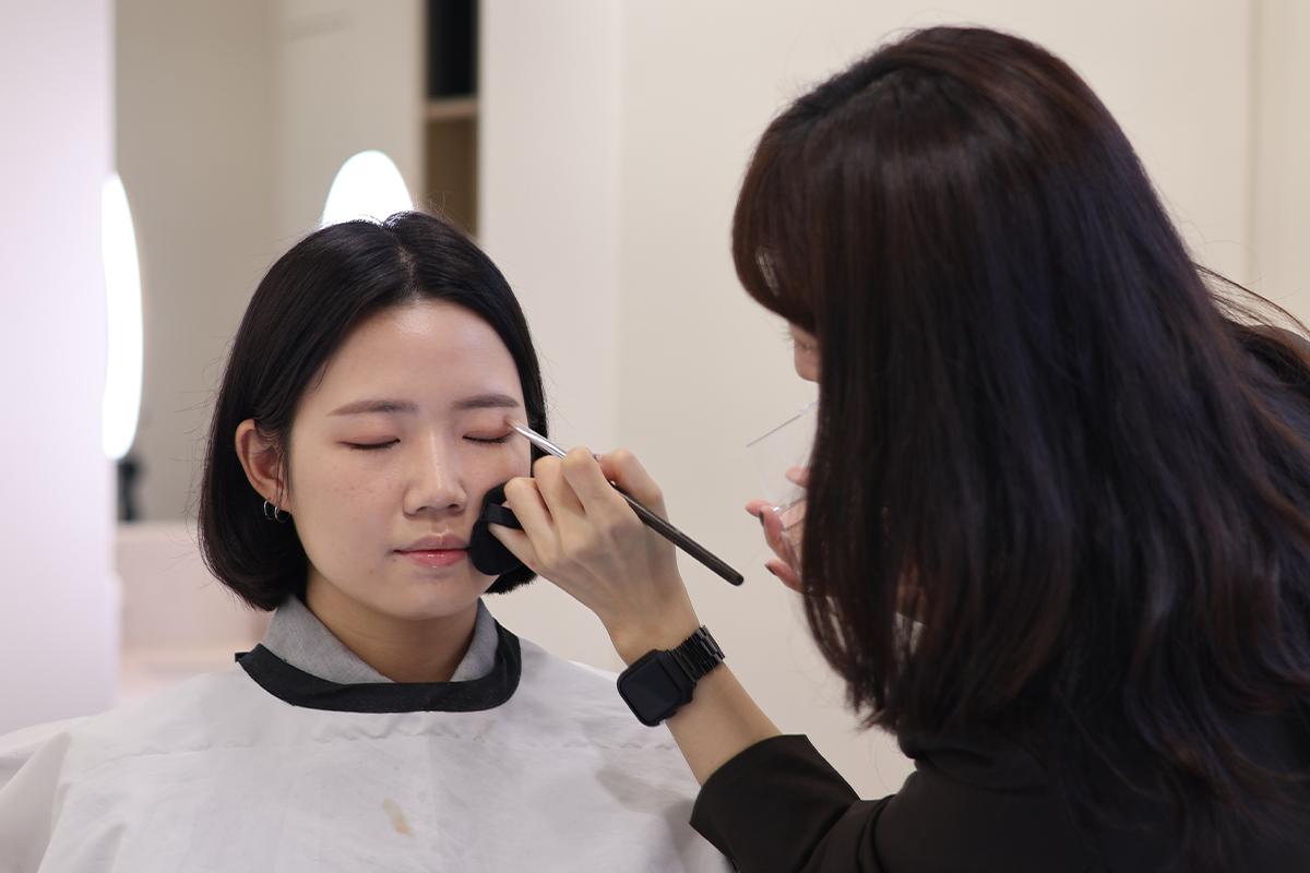 化妝師正在眉毛化妝過程中,展示了眉毛造型的細緻技巧。