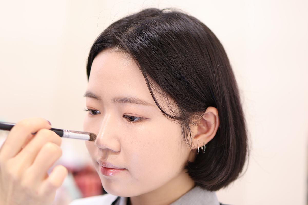 化妝過程中,化妝師正在進行粉底液塗抹,以呈現自然和諧的妝容效果。