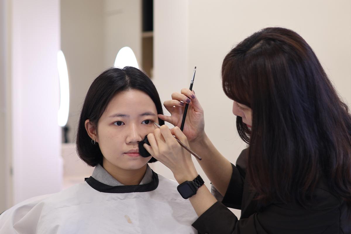 化妝師正在進行眉毛造型,展示了眉毛刷及眉筆的使用技巧。