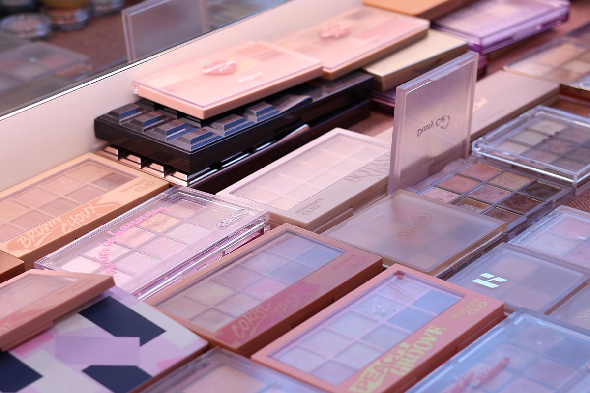 美容院化妝品展示,包括各種色號的眼影盤,品牌多樣,顯示其專業性。