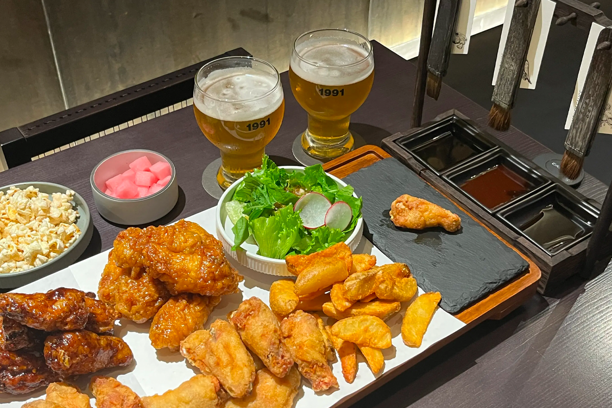 桥村笔房的招牌Platter，包含多种口味的炸鸡、薯条和沙拉，搭配两杯自制啤酒。