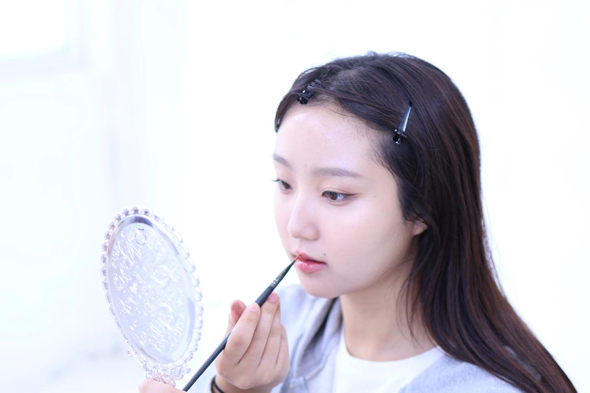 Styling process at Roa Makeup, adding the finishing touches with a blow dryer.