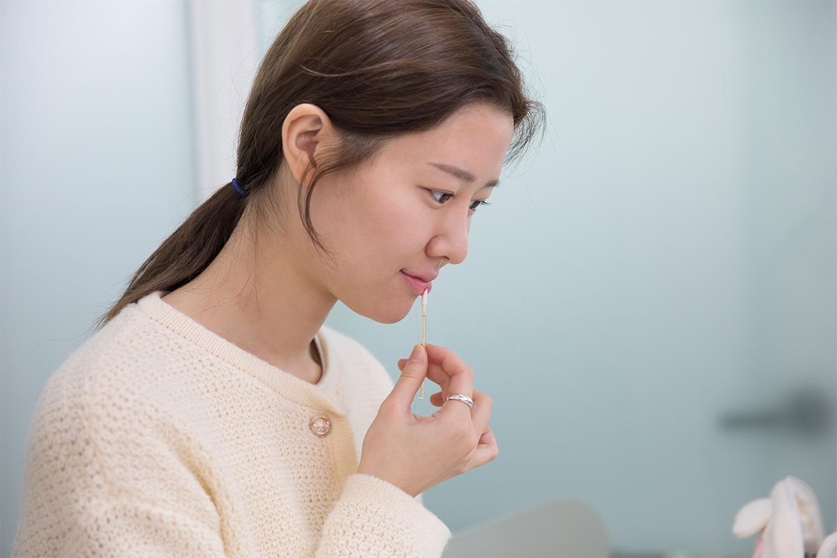 Experimenting with lipstick shades that complement your personal color at The Bom in Myeongdong, providing tailored makeup advice for an enhanced look.