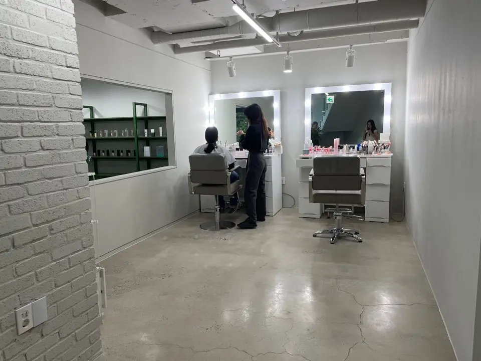 Makeup room at The Bom in Myeongdong, featuring large mirrors with bright lighting perfect for personalized makeup sessions that compliment your personal color analysis results.