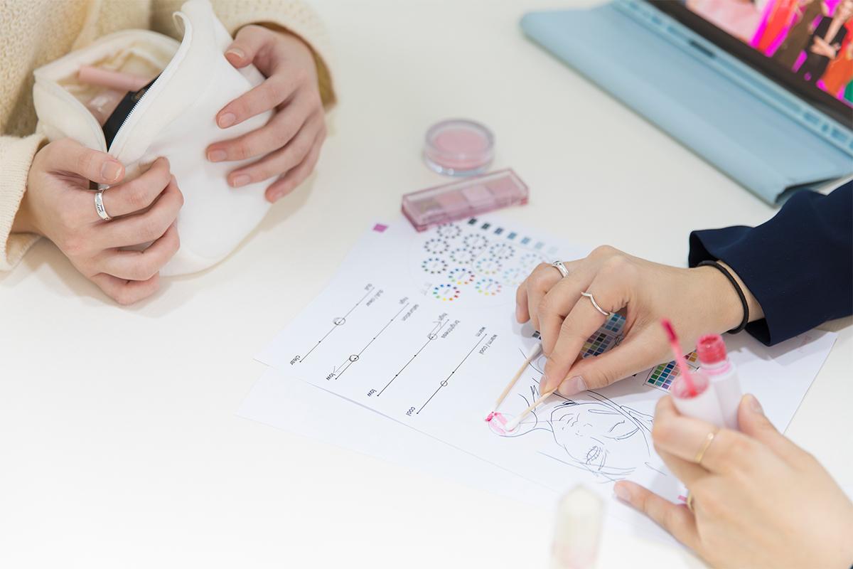 Analyzing personal cosmetic selections during a personal color analysis at The Bom in Myeongdong, enhancing makeup efficiency with expert color guidance.