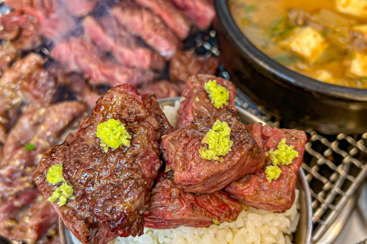 Grilled Hanwoo beef atop steaming rice at Udaepo, highlighting its rich flavor in Myeongdong.