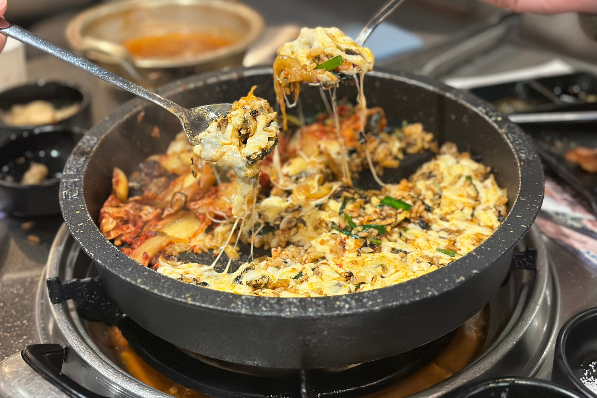 Mixing rice and cheese for a delicious final dish at Gunja Daehan Gopchang in Myeongdong, Seoul.