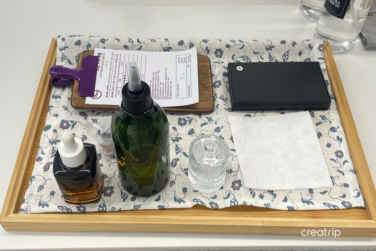 Tools and materials laid out for perfume making at Perfume Play Gangnam, including a scale and fragrances.
