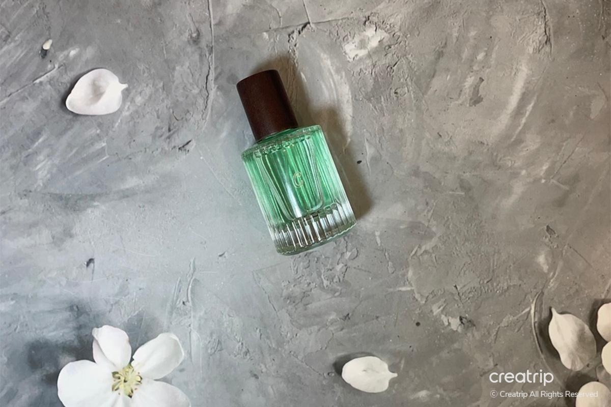 Perfume products styled with daily newspaper and feathers at Perfume Play Gangnam, demonstrating a creative setup.