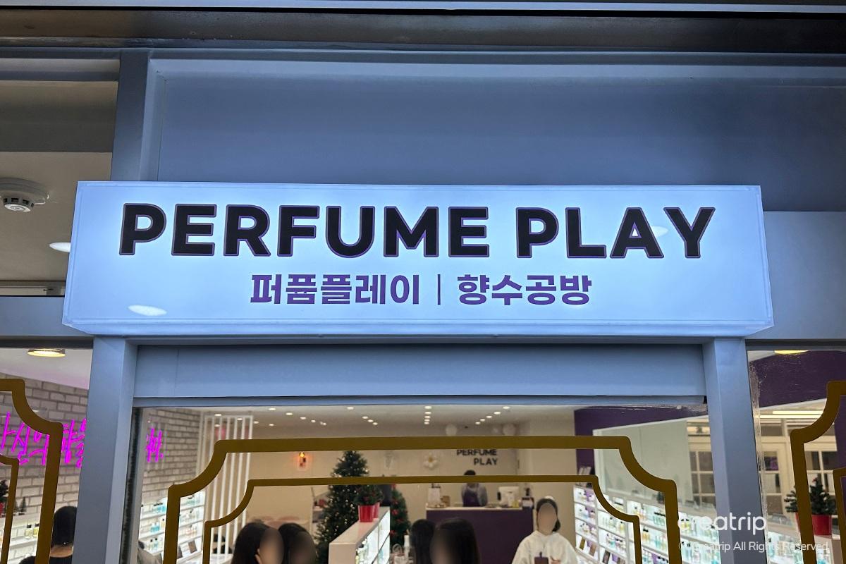 Entrance of Perfume Play in Gangnam, decorated with holiday gifts and a lit tree, inviting visitors to create their own perfumes.