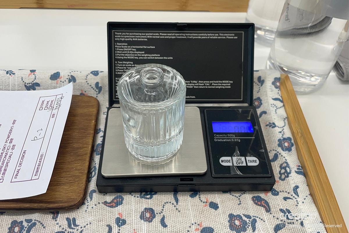 Delicate weighing of perfume ingredients at Perfume Play Gangnam as part of the fragrance creation process.