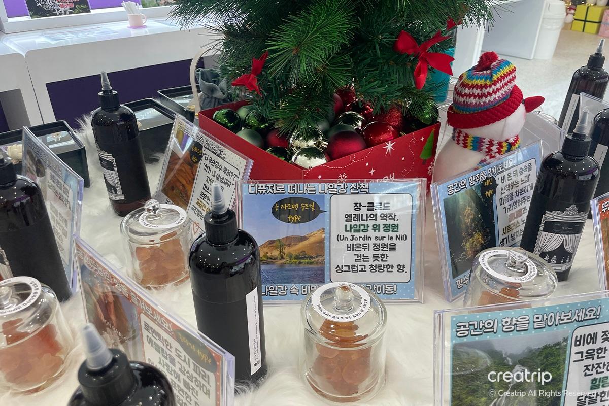 Decorated display at Perfume Play Gangnam featuring perfume bottles, festive decorations, and promotional signage.