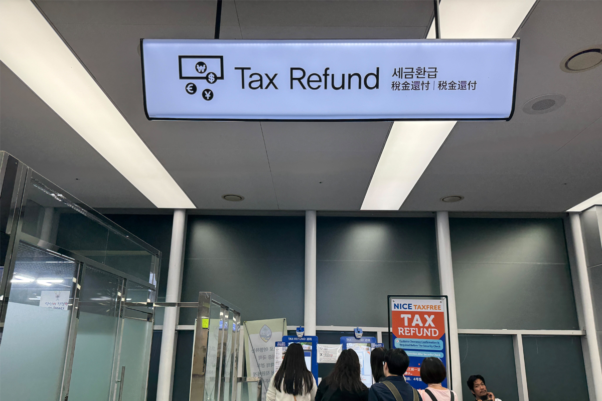 釜山金海機場的退稅機與標示，旅客正在排隊準備進行退稅