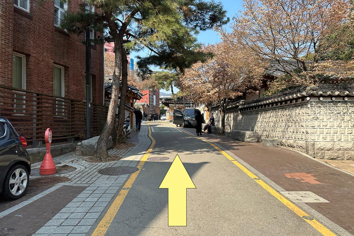 Scenic street view showing walking directions to Bukchon Hanok Village.