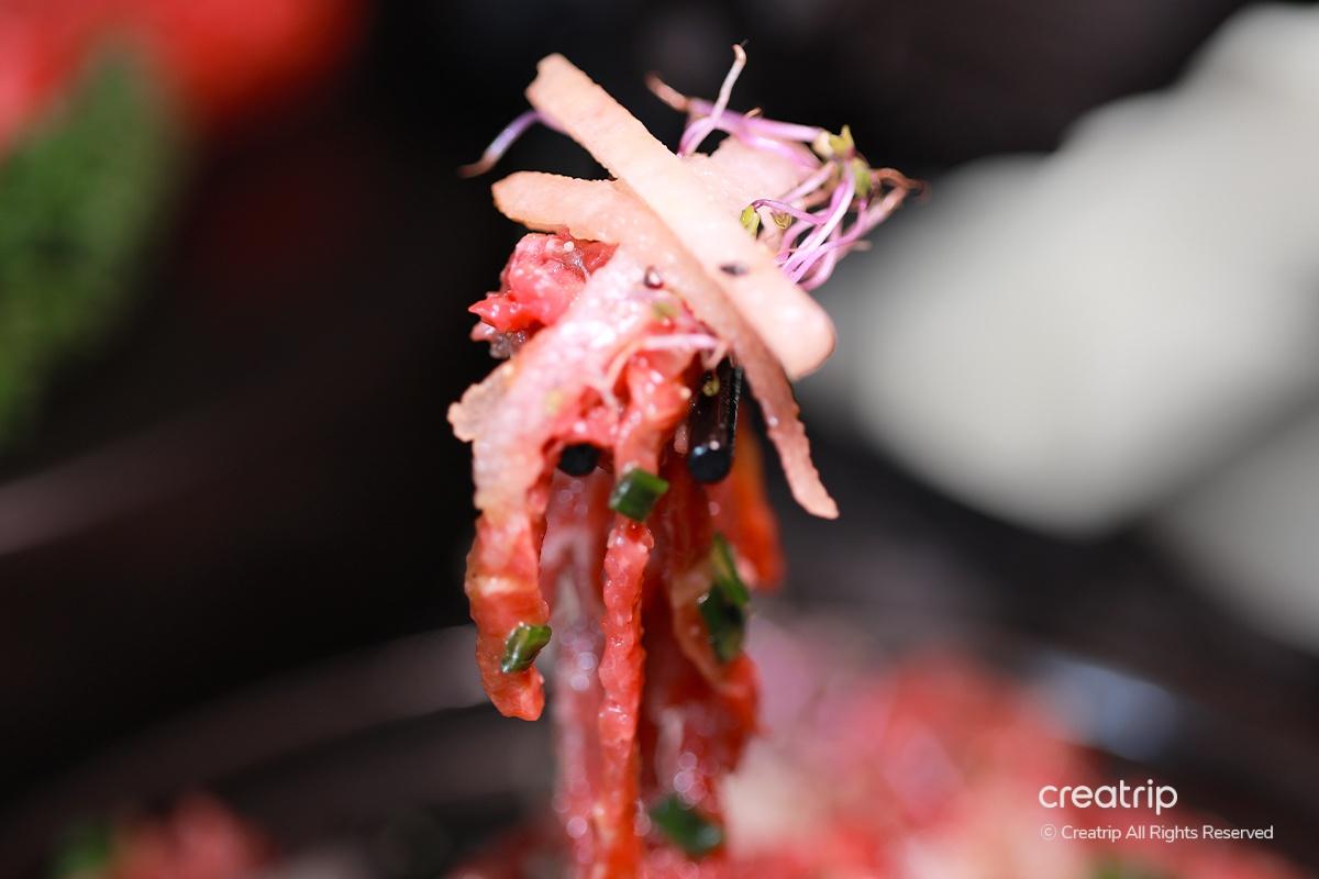 韓國生拌牛肉，夾起的牛肉條，顯示細膩的肉質