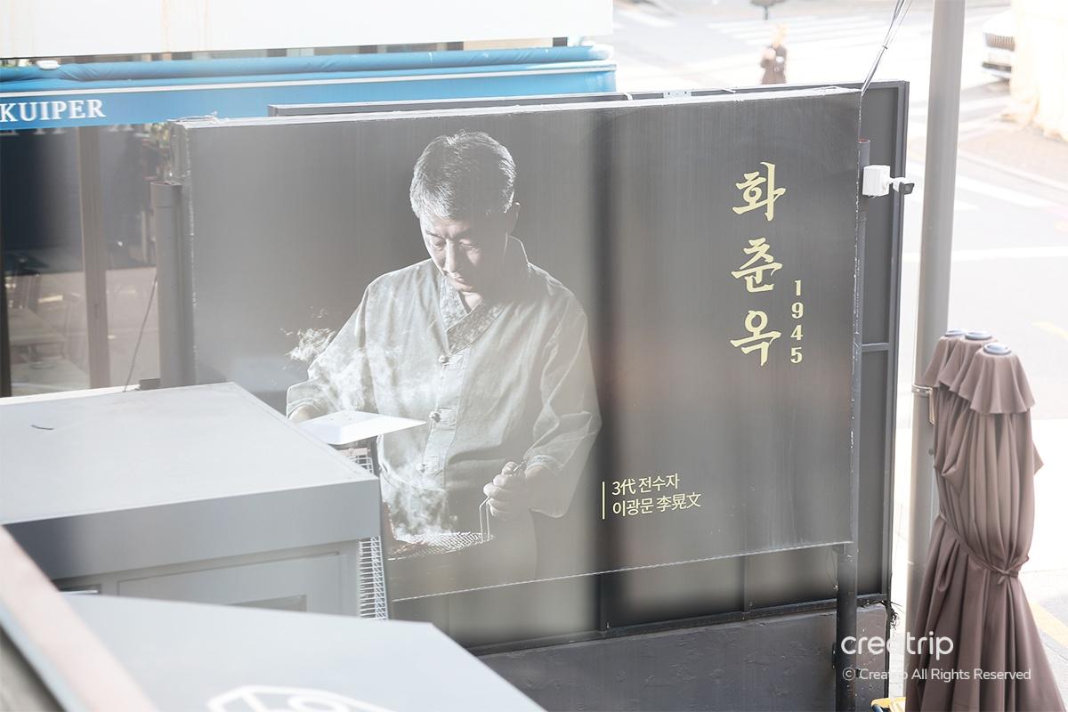 華春屋餐廳外觀，展示了一幅大型畫像，紀念自1945年以來的歷史