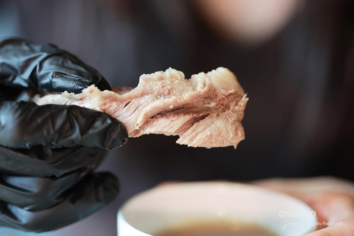 一手握住一塊牛排骨，看到牛肉的美味和細膩的紋理