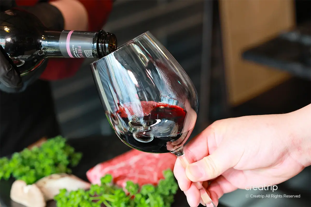 從酒瓶中的酒倒入酒杯，紅酒色調優雅