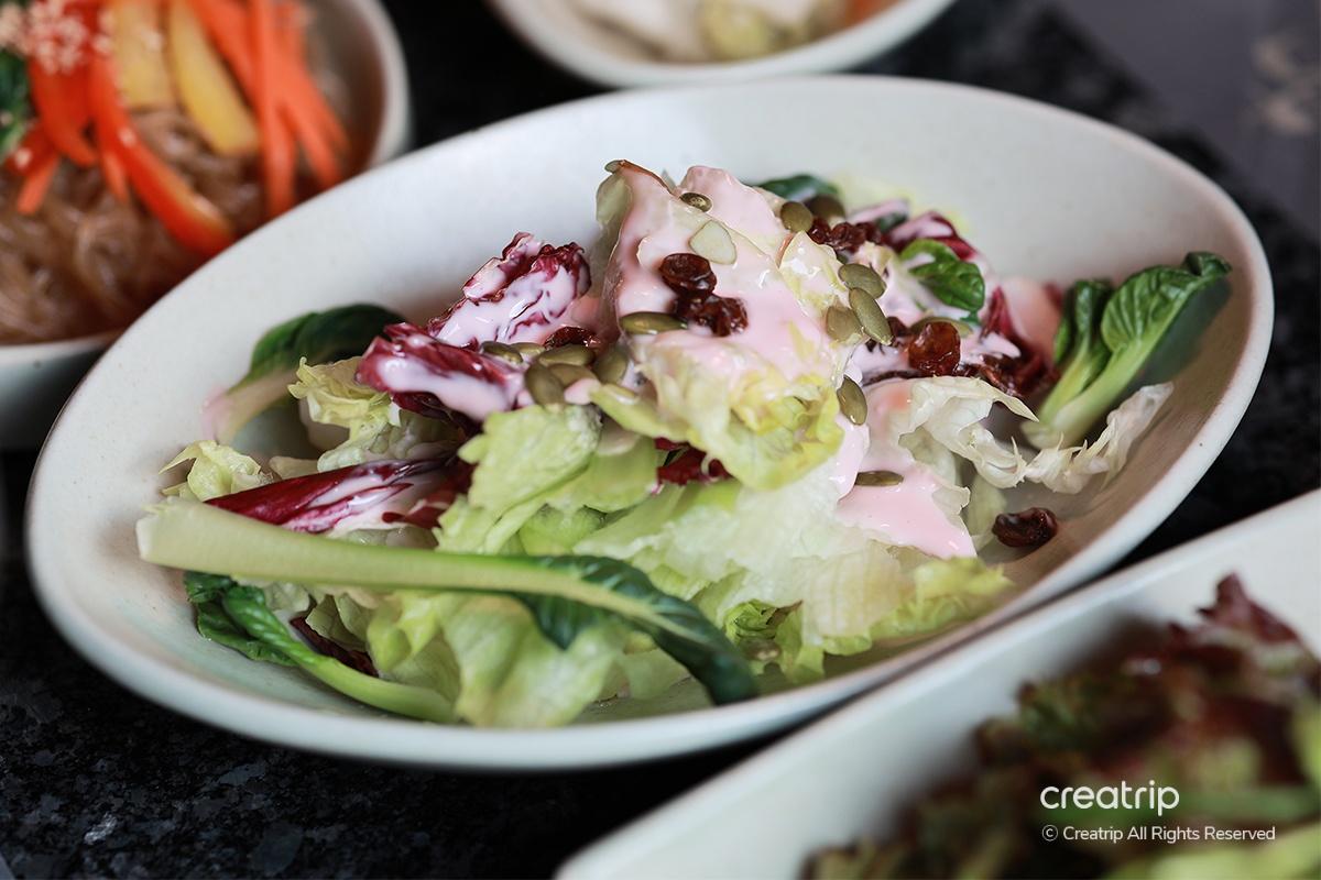 新鮮的蔬菜沙拉，混合了不同顏色的蔬菜和粉紅的沙拉醬