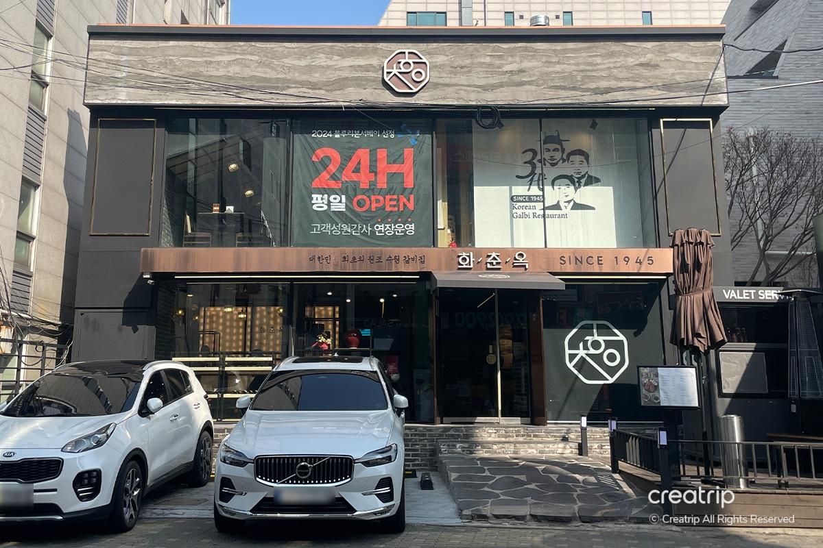 位於江南區的華春屋清潭店外觀，道路上停泊著一些車輛