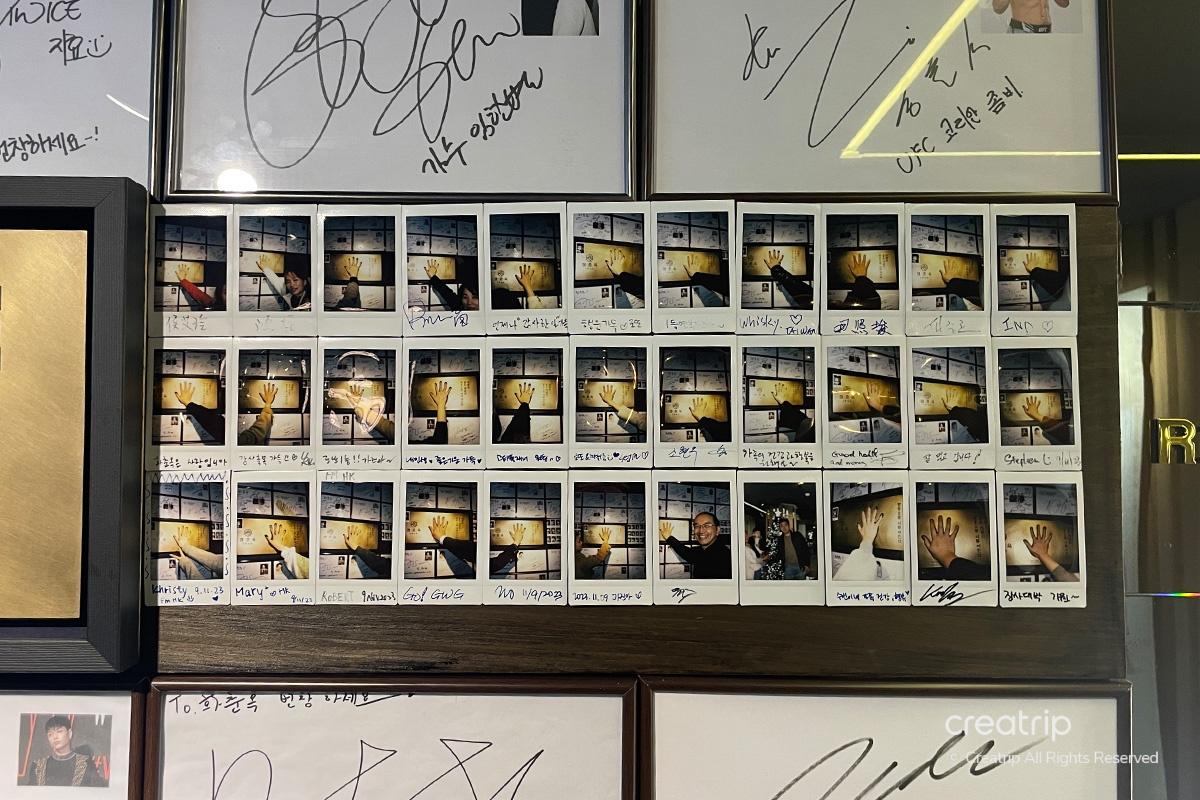 牆上展示了多位名人留下的簽名和拍立得照片