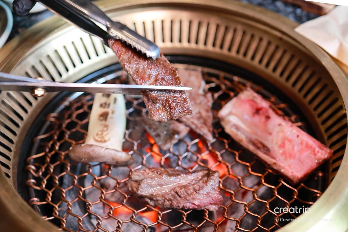 烤好的牛排夾起來展示，顯示柴火的高溫讓肉質可口
