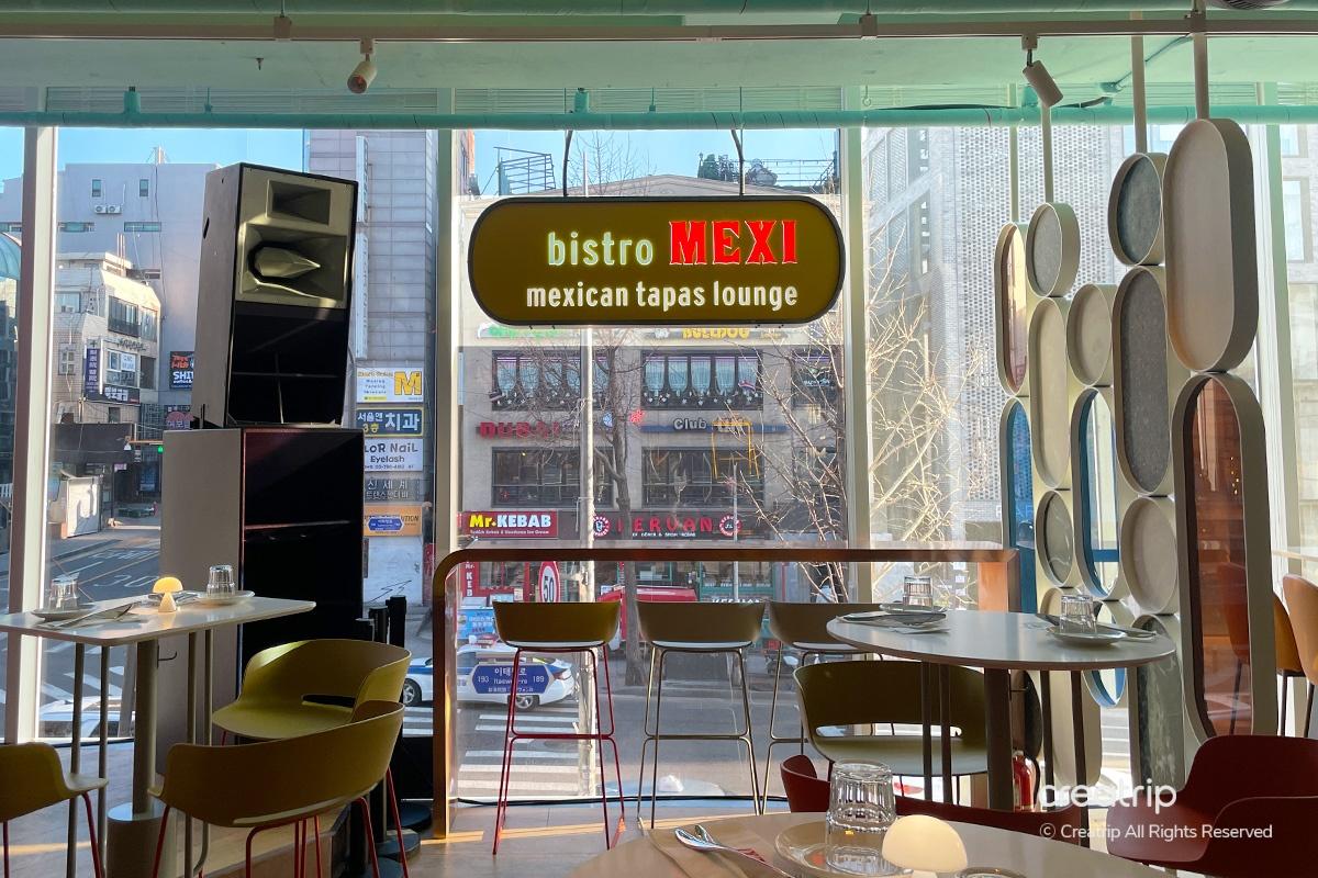梨泰院bistro MEXI餐厅内景，大窗户提供街道全景，营造时尚的用餐氛围。
