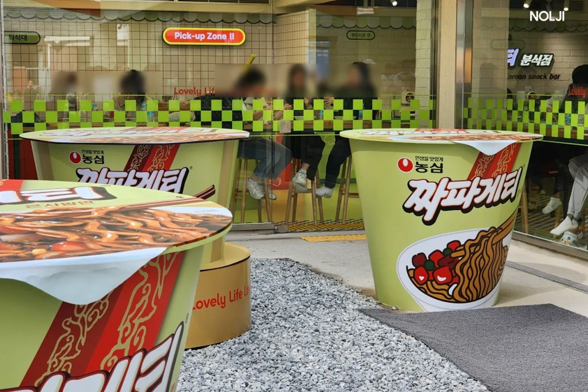 釜山のチャパゲティポップアップのインスタレーション、ラーメンのカップのデザインを模したテーブルが特徴です。