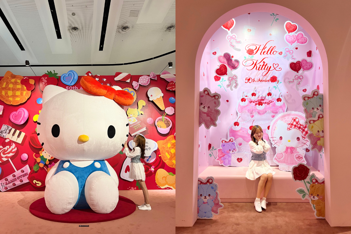 ハローキティ50週年特別展の展示会場で巨大なキティちゃんフィギュア。背景は赤を基調にしたポップでカラフルなイラストが描かれています。