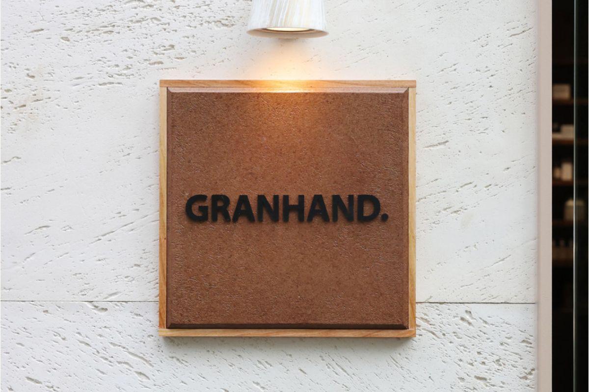 图片展示韩国著名香水品牌Granhand的门牌，它是韩国受欢迎的高性价比香水品牌之一。图中可见Granhand的标志，背景为高级的壁饰，非常适合在景福宫或弘大等地探索当地的香水店。