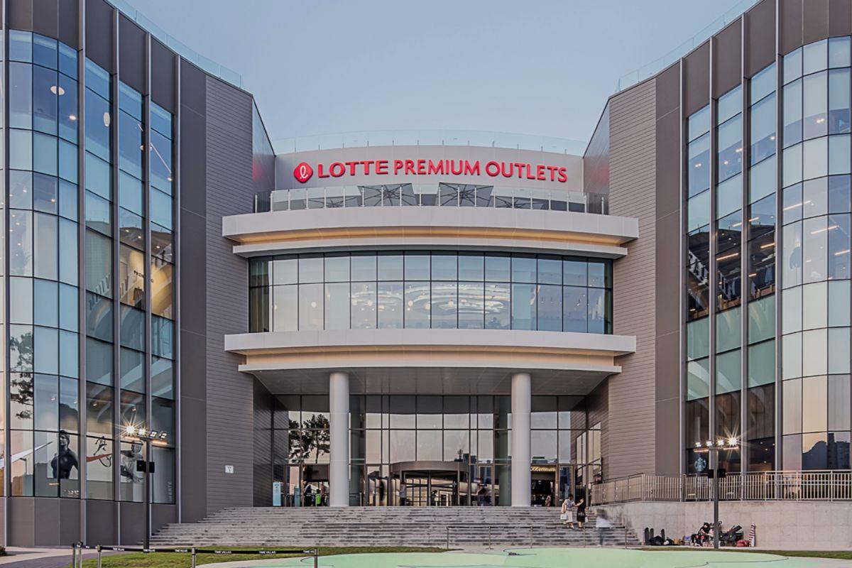 這張圖片顯示樂天Outlets首爾分店的外觀，展示出宏偉建築和明亮的亮眼標誌。圖片最佳化以提高SEO排名並促進韓國旅行內容。