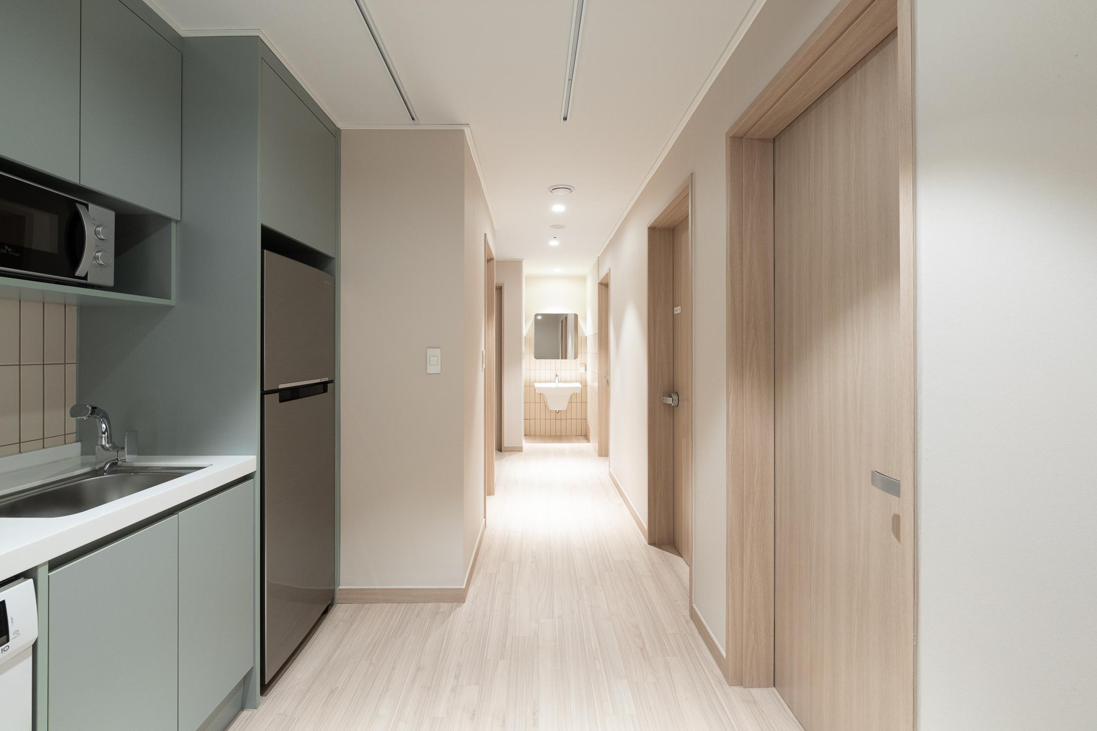 ห้องโถงหรือทางเดินใน Co-living House Mangrove Sinchon ซึ่งมีครัวเล็กตู้เย็นและอ่างล้างจานรวมอยู่ในพื้นที่เดียวกัน