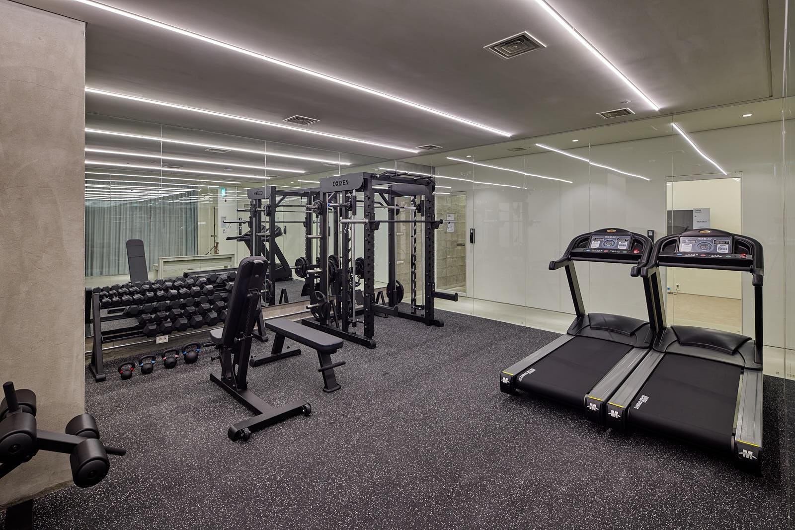 ห้องออกกำลังกายใน Co-living House Mangrove Sinseol มีเครื่องออกกำลังกายที่ทันสมัยและพื้นที่กระจกขนาดใหญ่สำหรับฝึกออกกำลังกาย