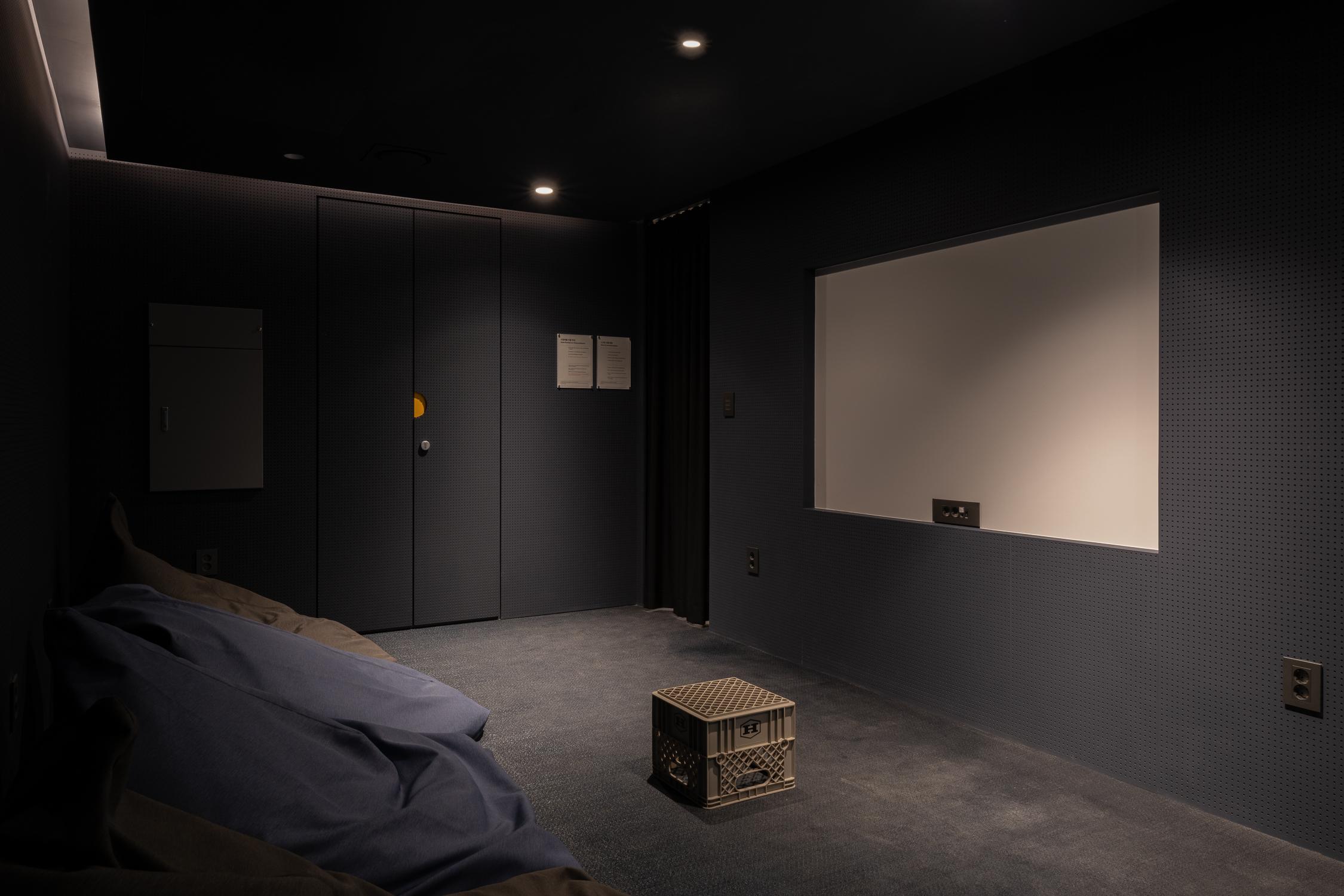 ห้องมืดที่มีจอโปรเจ็กเตอร์ใน Co-living House Mangrove Sinchon สำหรับการดูภาพยนตร์หรือการนำเสนอวิดีโอ