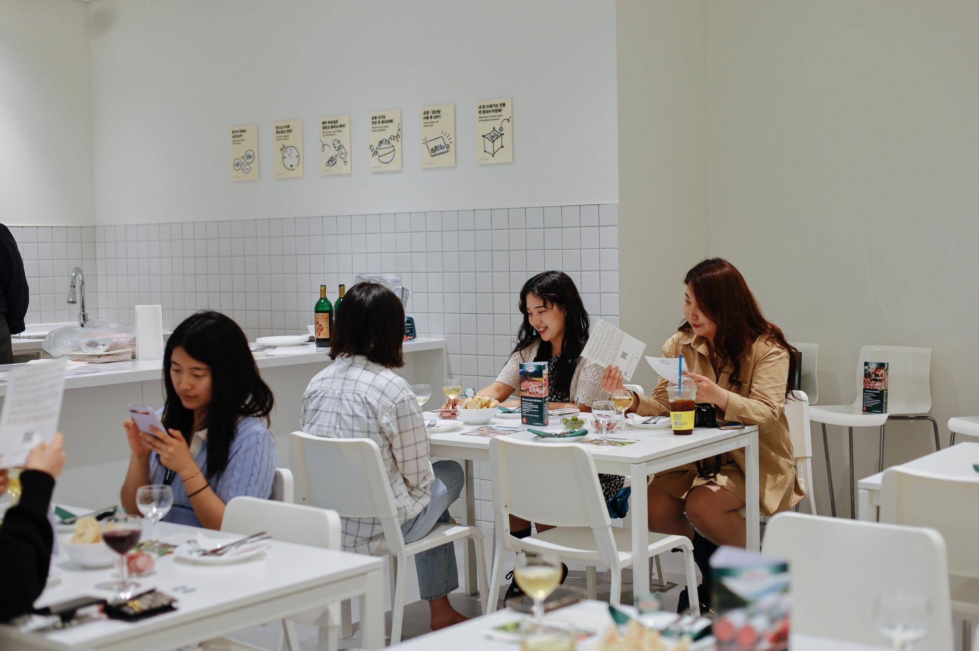 กลุ่มคนใน Co-living House Mangrove ที่นั่งรวมกันเพื่อทานอาหารและทำกิจกรรมร่วมกันในพื้นที่ครัวส่วนกลางของชุมชน