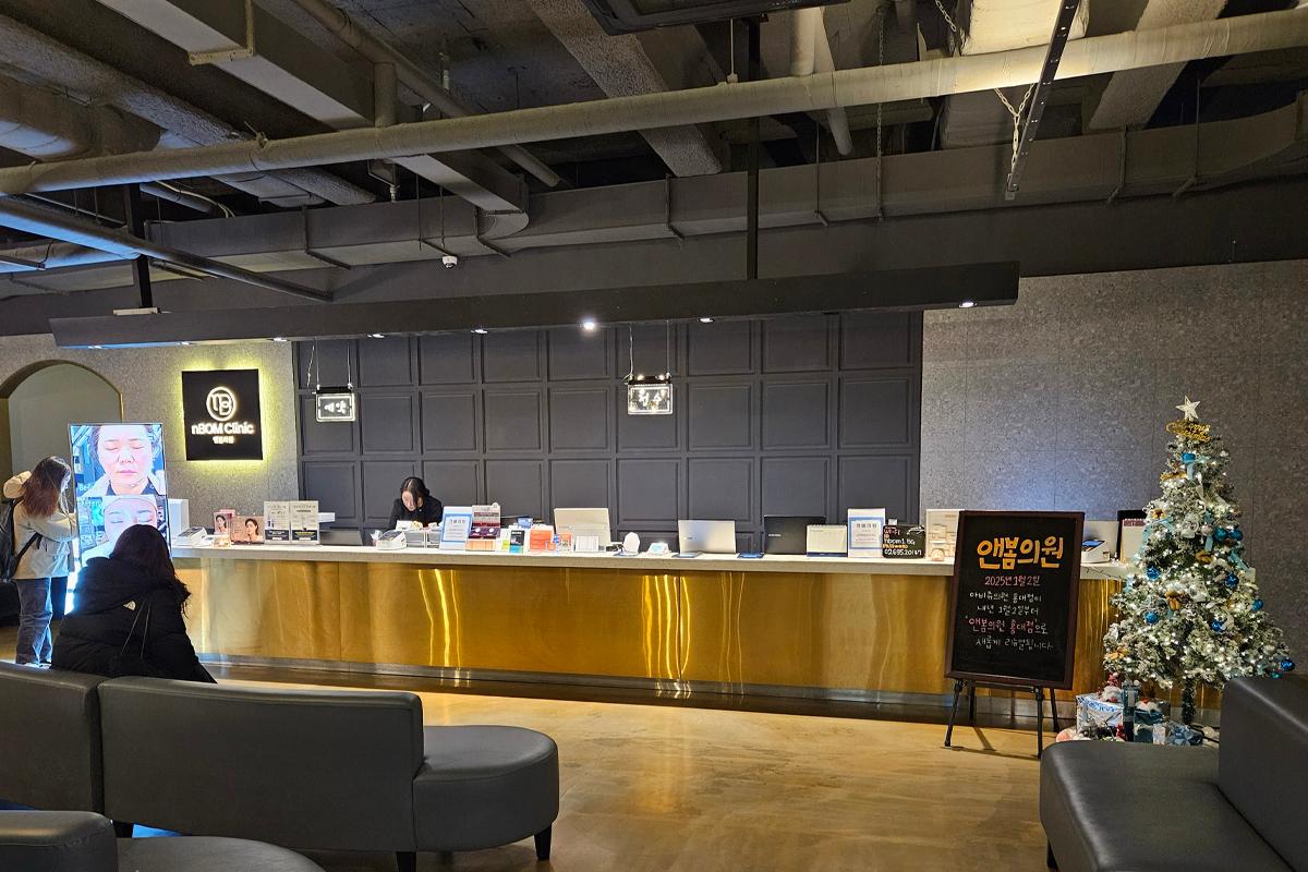 nBOM Clinic的前臺環境，設計簡約大方，牆上掛有招牌，提供皮膚科和美容服務。