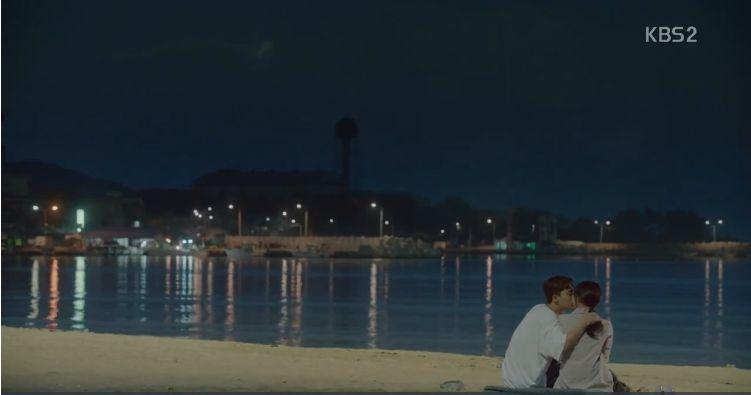 韩剧《三流之路》中浪漫的沙滩夜景，背景是静谧的海岸线。