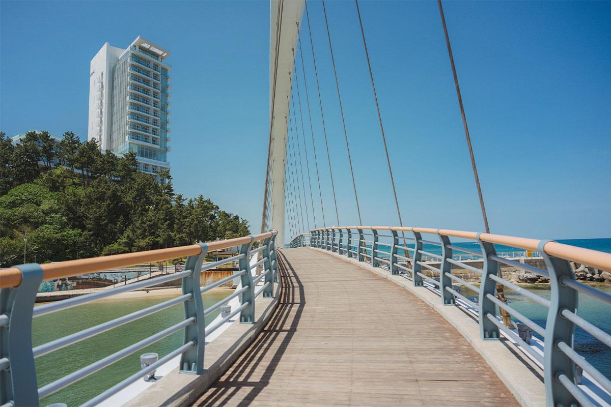 Wide angle view of Solbaram Bridge crossing a serene waterway in Gangneung.